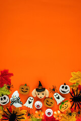 Cute halloween decorations and maple leaves on orange background for Halloween holiday concept.