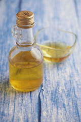 Oil bottle and small dish on a wooden background