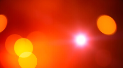 Abstract festive background with warm hued blurred bokeh spots and a glowing bright point of light. Ideal for holiday, celebration, or abstract design projects.