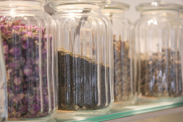 Colorful jars filled with dried herbs and flowers display