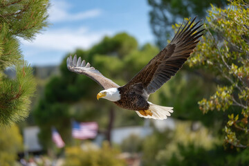 Fototapeta premium Majestic bald eagle soaring through clear blue sky with vibrant greenery in the background