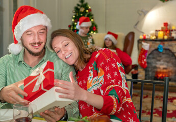 Christmas Present Gift Box of Xmas surprise celebration family together and interior magic Lighting glowing tree. Merry Christmas! happy family and children fun magic gift near tree at evening at home