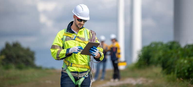 Male man engineer inspection by tablet gesture check control wind power machine out door wind energy factory. technician professional worker check wind power machine turbine field inspection