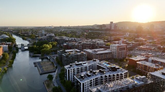 Aerial view of modern waterfront district with high-rise buildings and riverside paths, Montreal twilight skyline. g.