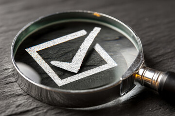 Magnifying glass inspecting tile with acceptance criteria check mark in minimal lighting