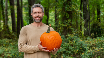 Greengrocer man Halloween pumpkin growing. Greengrocer harvesting. Autumn vegetable harvest. Farmer...