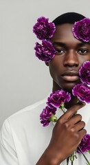 Portrait of a man with purple flowers against a gray background.