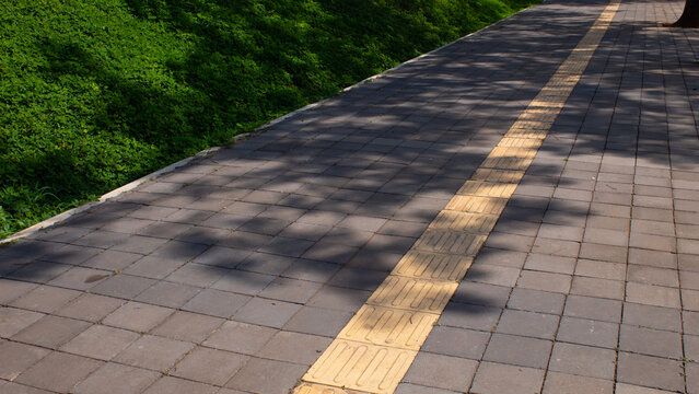 Yellow Tactile Paving Path on City Sidewalk