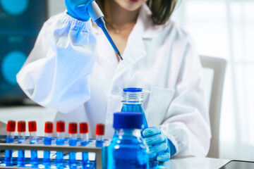 Fototapeta premium An Asian female scientist carefully analyzes microscopic samples and chemical solutions in a modern laboratory, conducting biology, microbiology, pharmaceutical, and medical research with precision