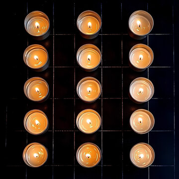 Long-exposure shot of lit candles arranged to spell &lsquo;PEACE&rsquo; in a dark room or outdoor memorial. Flame glow sharp against the darkness, zero noise or overexposure.