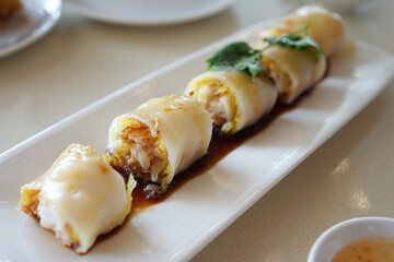 Close up Rice noodle roll, thin crépe roll made from a wide strip of shahe fen, filled with shrimp, beef, vegetables, or other ingredients