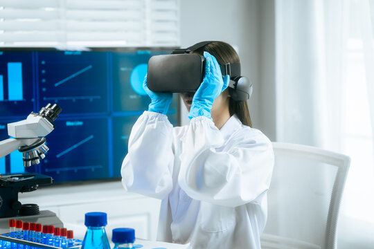 An Asian female scientist wearing a virtual reality headset explores digital simulations in a modern laboratory, surrounded by microscopes, test tubes,merging VR technology with advanced scientific