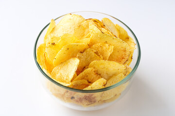 A clear glass bowl filled with potato chips, isolated on a clean white background.