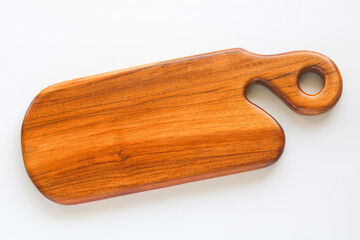 A crafted wooden cutting board with a unique, ergonomic handle and a round cutout for hanging, laid flat on a clean white background. A kitchen essential for chopping, serving, or display.