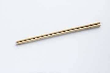 A simple, high-angle close-up of a light wooden or bamboo chopsticks. A utensil used in various Asian cuisines.