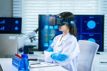 An Asian female scientist in a modern lab interacts with 3D holographic data using VR/MR headset,...