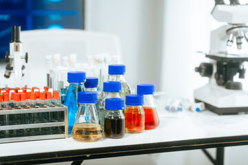 A bright and well-organized laboratory filled with colorful chemical solutions, microscopes, science safety,chemical experiments,safety in a professional biological and chemical research environment