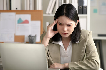 Young Asian Businesswoman looking stressed from work, Young businesswoman working at office feels overworked and burnout