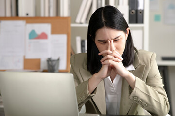 Young Asian Businesswoman suffering from eyestrain while working on the computer, Young businesswoman working at office feels overworked and  burnout, Healthcare office syndrome concept