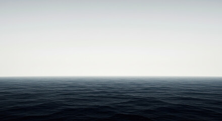 Fototapeta premium Vast dark ocean under a bright hazy sky horizon.