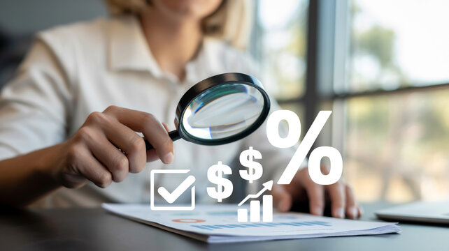 A woman analyzing financial data with a magnifying glass for investment decisions