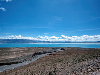 Vast blue lake with clear sky and dry land around