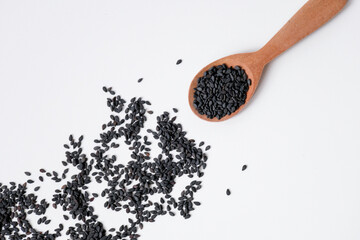 Black sesame seeds in wooden spoon isolated on white background