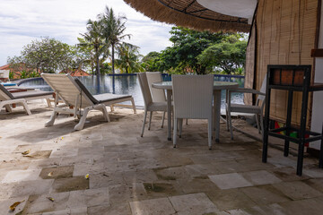 Poolside area with a white umbrella and chairs