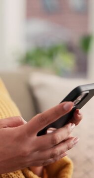 Hands, woman and phone on sofa for typing, scroll and text message in living room. Female person, networking and mobile app for creating profile, chat and explore on dating website in apartment
