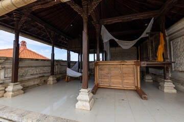 Wooden structure with a white canopy and a white bed