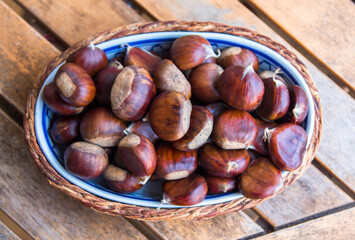 Tray with delicious chestnuts on a vintage wooden background