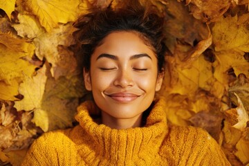 Peaceful woman smiling with eyes closed in autumn leaves