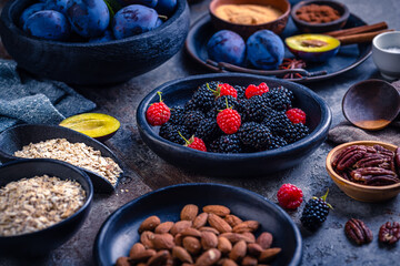 Freshly picked berries and plums with healthy baking ingredients