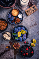 Freshly picked berries and plums with healthy baking ingredients