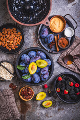 Freshly picked berries and plums with healthy baking ingredients