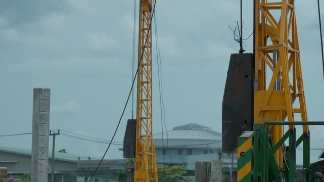 Pile-driving (copra) part of the excavator. Pile driving works at the construction site. Modern hydraulic lifting mechanisms.