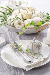 Place settings with white pumpkins for Thanksgiving