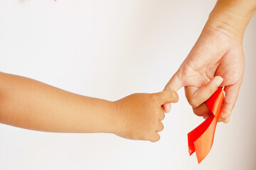 Mother holding her child's hand with a red awareness ribbon, symbol of support, care, and World...