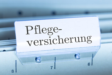 Schild mit der Aufschrift PFLEGEVERSICHERUNG an einem Hängemappenregister