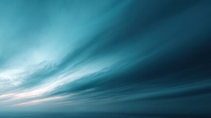 A serene ocean scene showcasing dramatic, swirling clouds in shades of blue and soft light, evoking a tranquil and expansive atmosphere.