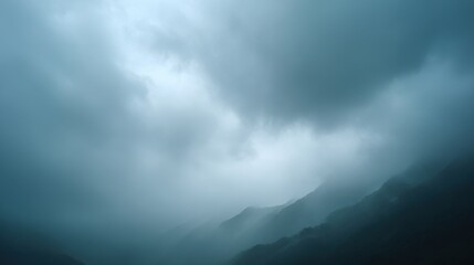 A misty mountain landscape under overcast skies, creating a serene and moody atmosphere.