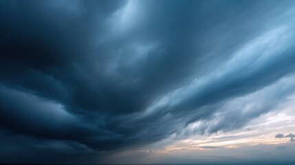 The image depicts a dramatic sky filled with swirling, dark clouds and hints of light at the horizon, creating a moody and atmospheric scene.
