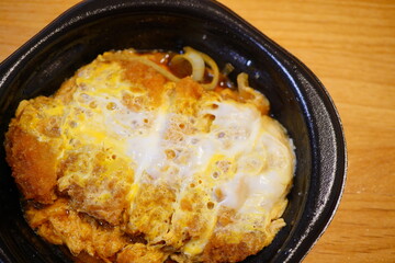 半熟卵がとろける熱々のカツ丼。サクサクのカツとだしの香りが食欲をそそる日本の定番丼メニュー。