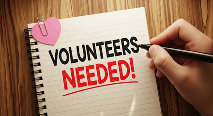 Volunteers Needed Concept: Hand Writing Message on Notepad with Heart Clip. Ideal for Charity, Community Outreach, and Nonprofit Campaigns. Urgent Call