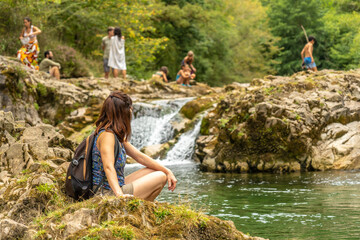 Hiker resting near waterfall in natural paradise, dobra river, asturias, spain