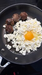 fried eggs with meet and cottage cheese in frying pan High protein meal for diet.