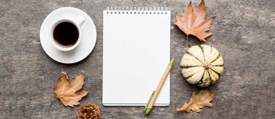 Autumn composition: fallen leaves and craft sketchbook mock up on colored background. Top view. Flat lay with copy space