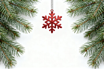 Red snowflake ornament on green pine branches