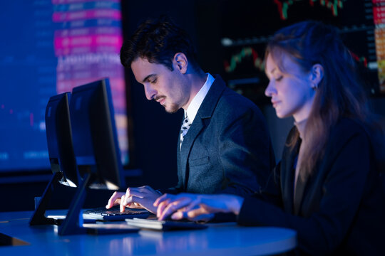 Professional team of stockbrokers monitoring cryptocurrency and forex charts in a modern trading room. - Powered by Adobe