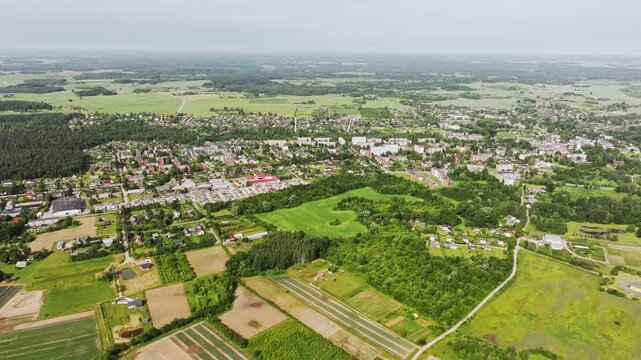 Aerial drone scene of Dobele town surrounded by fields on cloudy morning